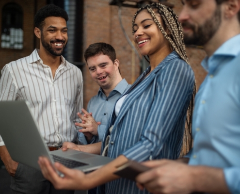Cheerful,Young,Businesspeople,With,Laptop,Working,In,Office,,Social,Inclusion